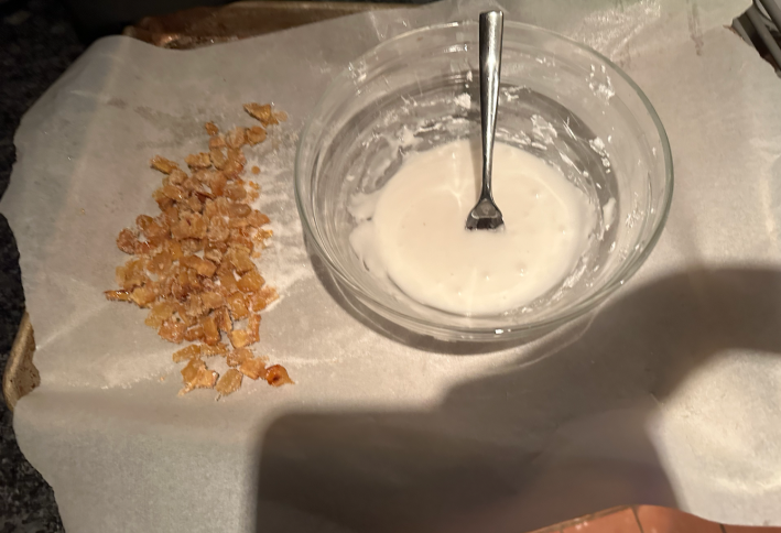 A bowl of icing and a mound of candied ginger.